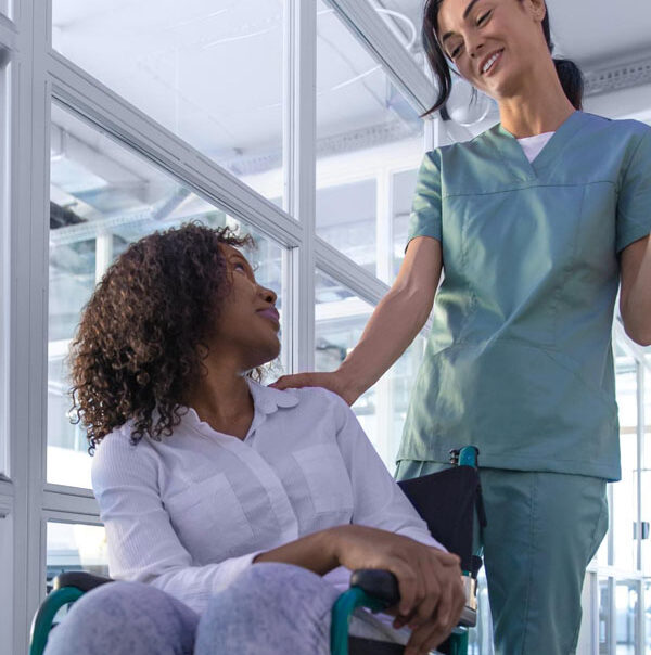 Aus Care Community Services | Local NDIS Providers | NDIS Support at Home After Hospital: What to Expect Support worker checking in with a person who uses a wheelchair