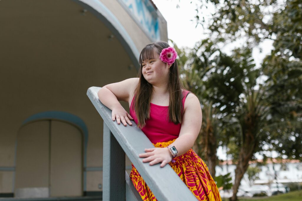 Young woman in a colourful outfit smiling on a staircase