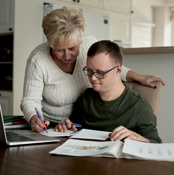 Support worker and a person sitting together at a kitchen table
